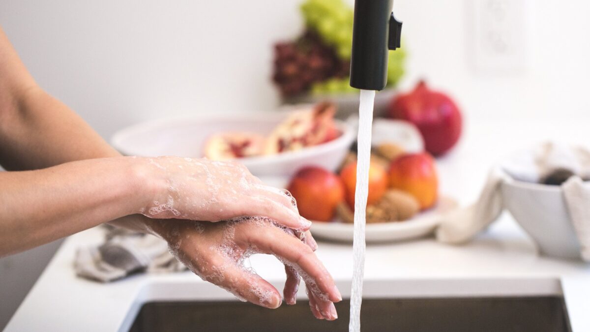 Person washing hands under a tap