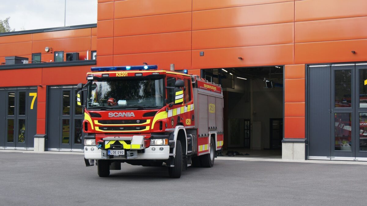A Scania fire truck in front of a fire station