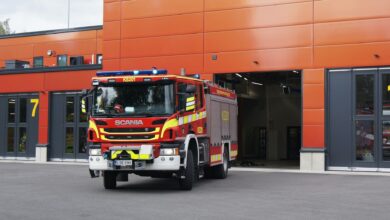 A Scania fire truck in front of a fire station